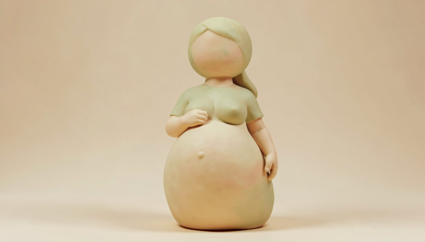 Soft clay-model render of a maternity silhouette in warm amber and soft cream tones, peaceful rounded form